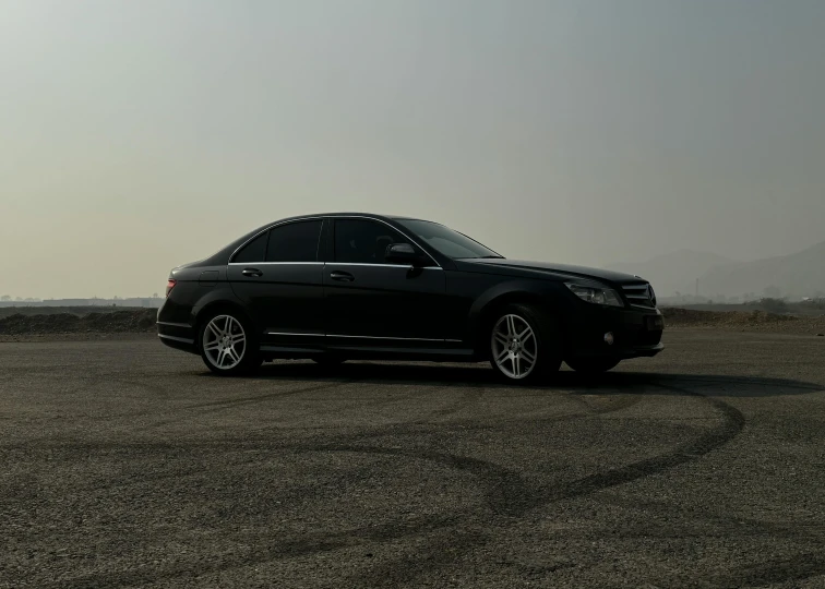 a black car is parked near the side of the road