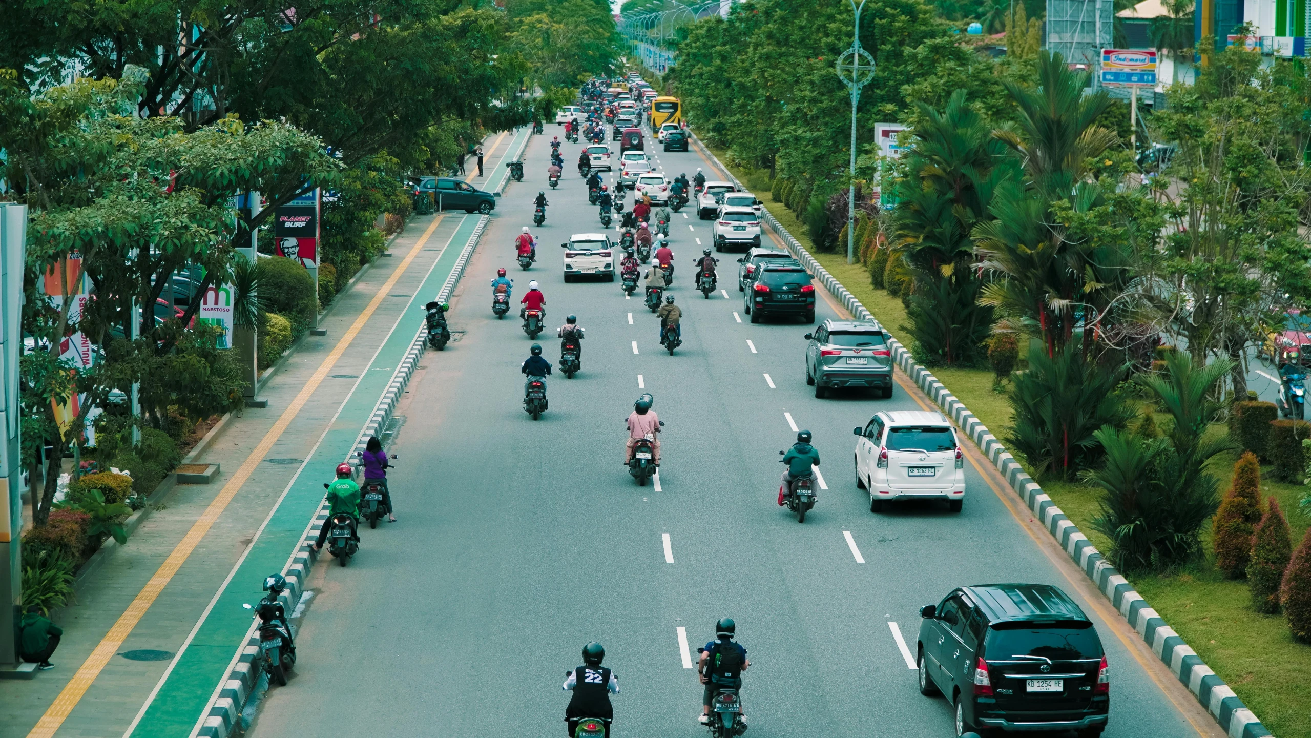 motorcycle riders traveling on a highway near cars