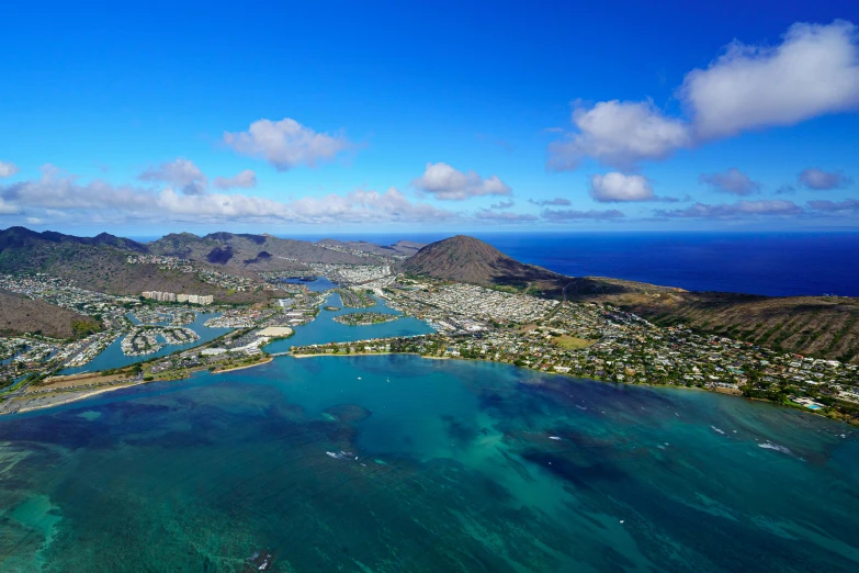 the view from an airplane, looking down on a town and lagoon in a beautiful, crystal clear blue sea