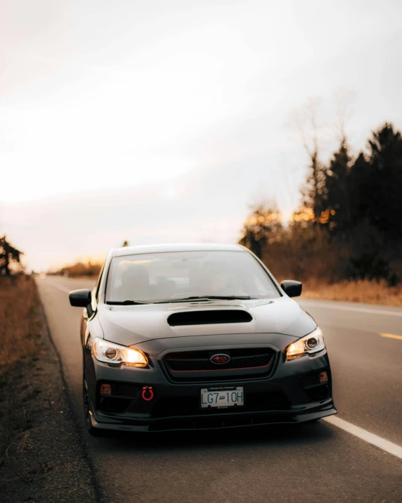 an odd looking car drives down a road