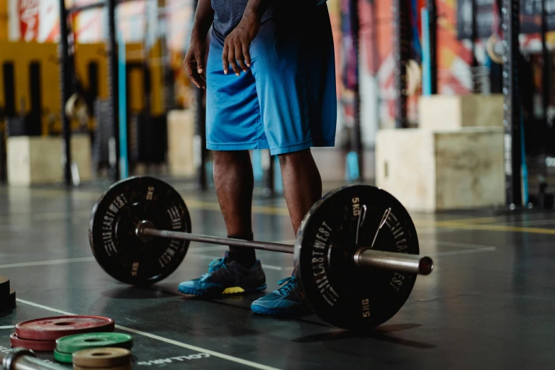 the young man is holding the barbell in his hand