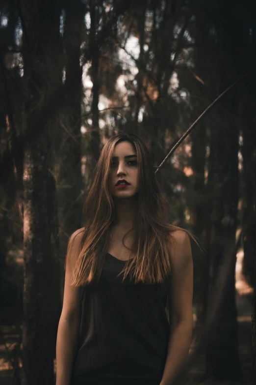 a girl in the woods posing with a sword