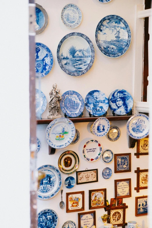 a wall filled with blue and white plates hanging