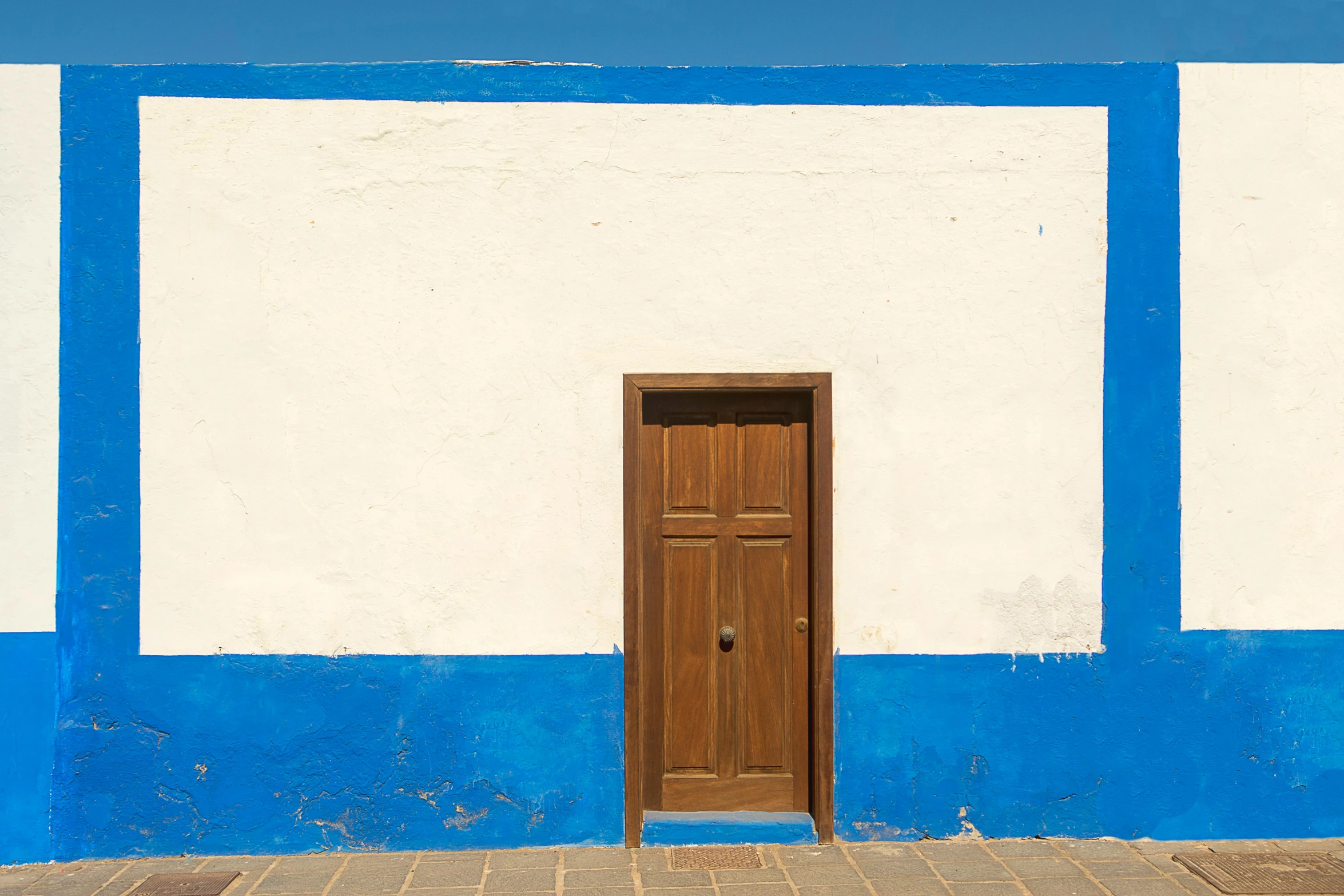 a white and blue house has a wooden door