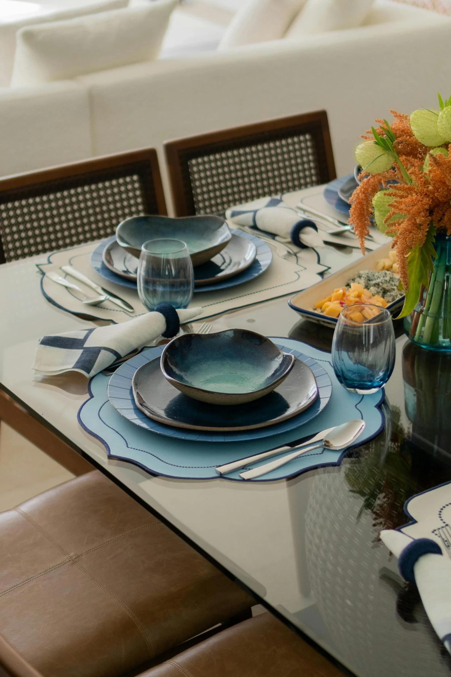 a table set with dishes and blue glasses