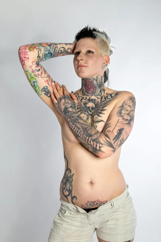 a man with tattoo standing against a wall