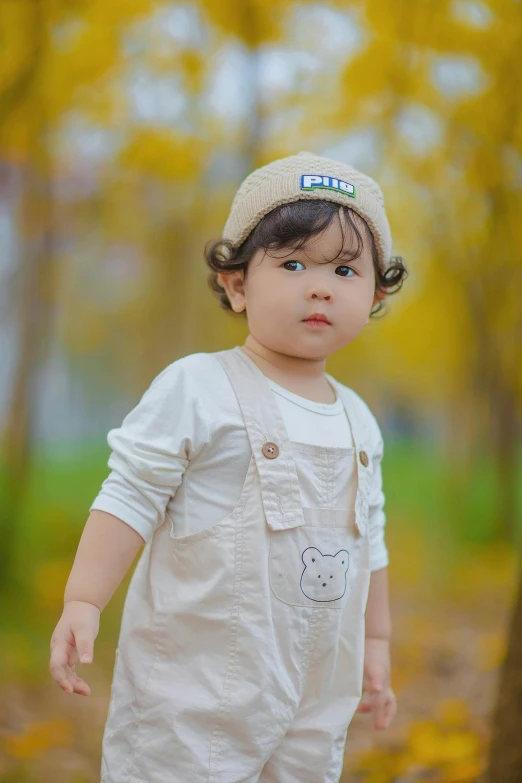 a little girl is standing in the woods