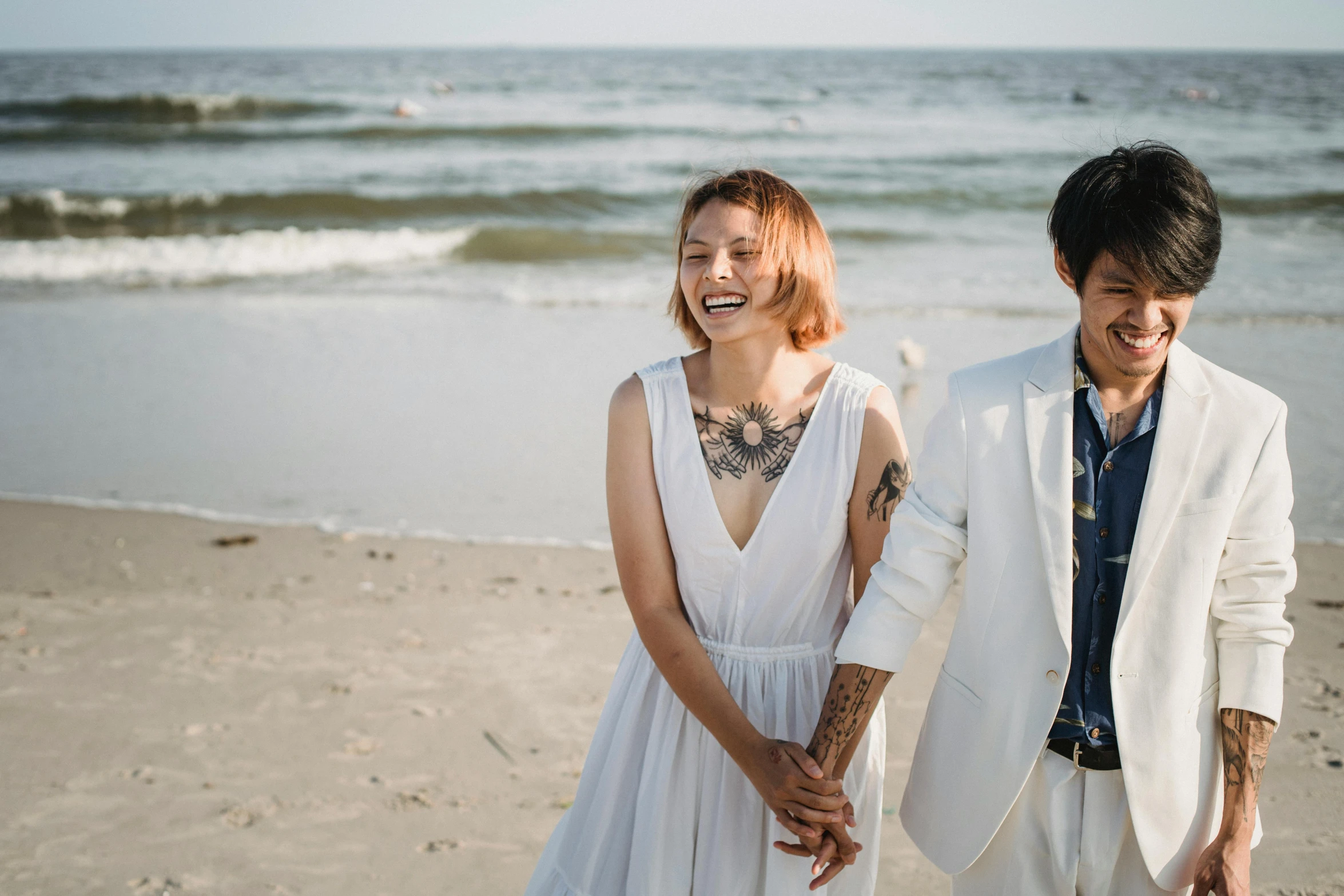 the man and woman are standing on the beach