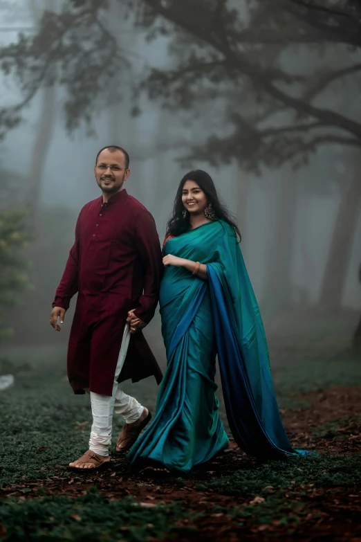 two people dressed in traditional clothes pose together