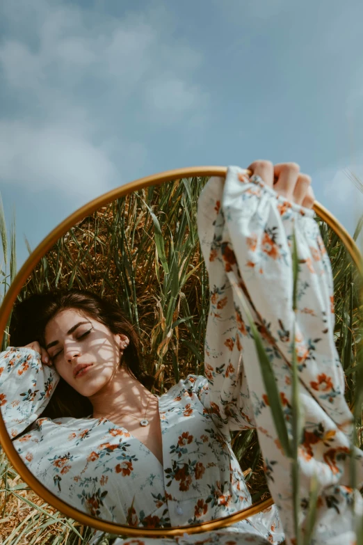 a woman looks back in a round mirror