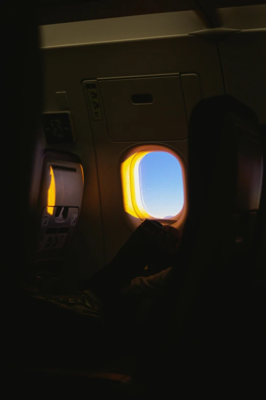 someone sits in an airplane while looking out the window