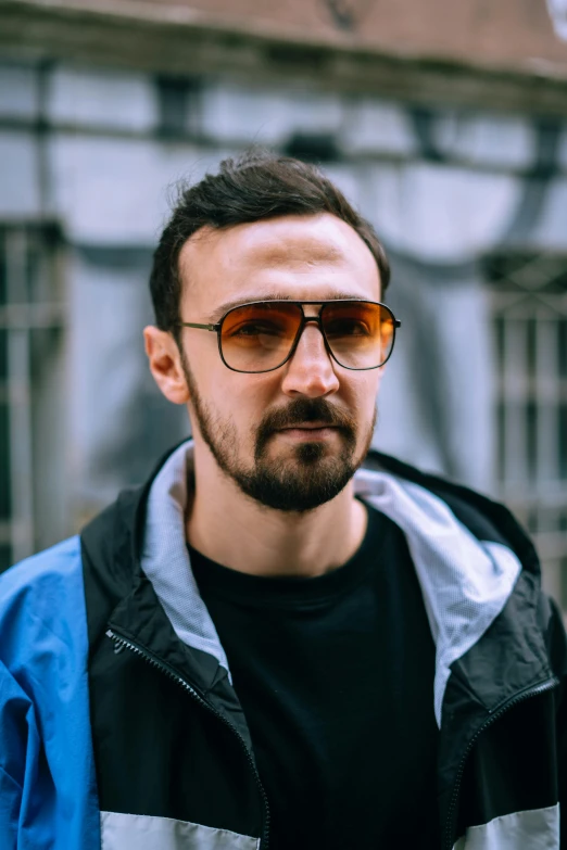 a man with sunglasses is standing in front of a building