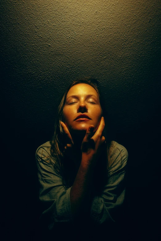 a woman with her head resting on the hands of her chest