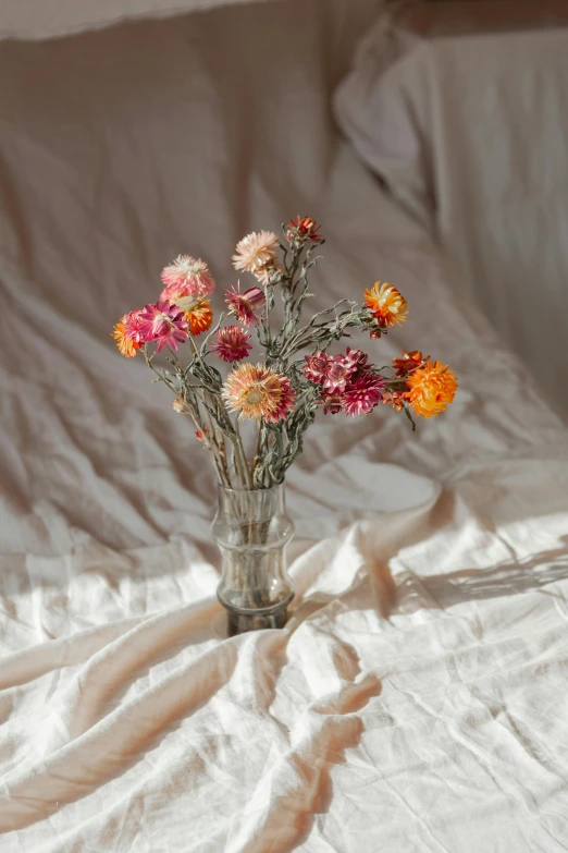 many colorful flowers are in a glass vase