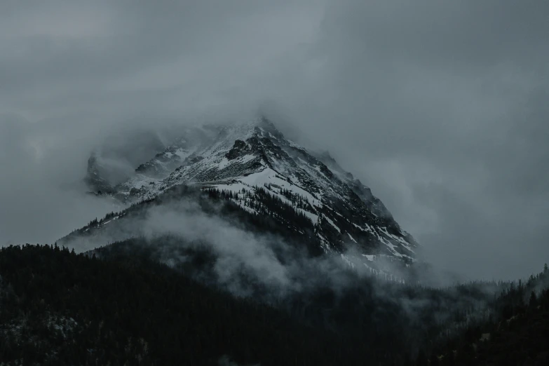 a mountain peak covered with clouds and fog