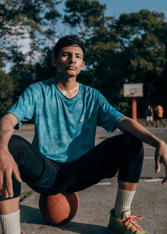 a man sitting on top of a basketball in a parking lot