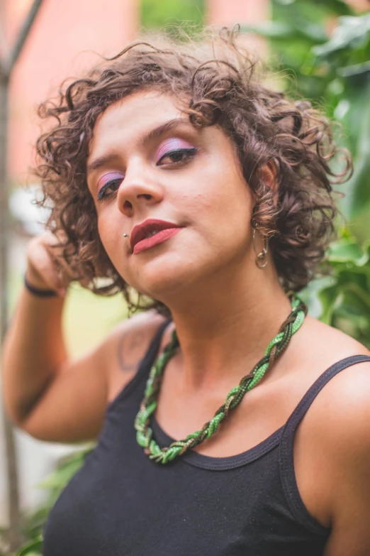 the woman is posing for a pograph with her face covered by green beads