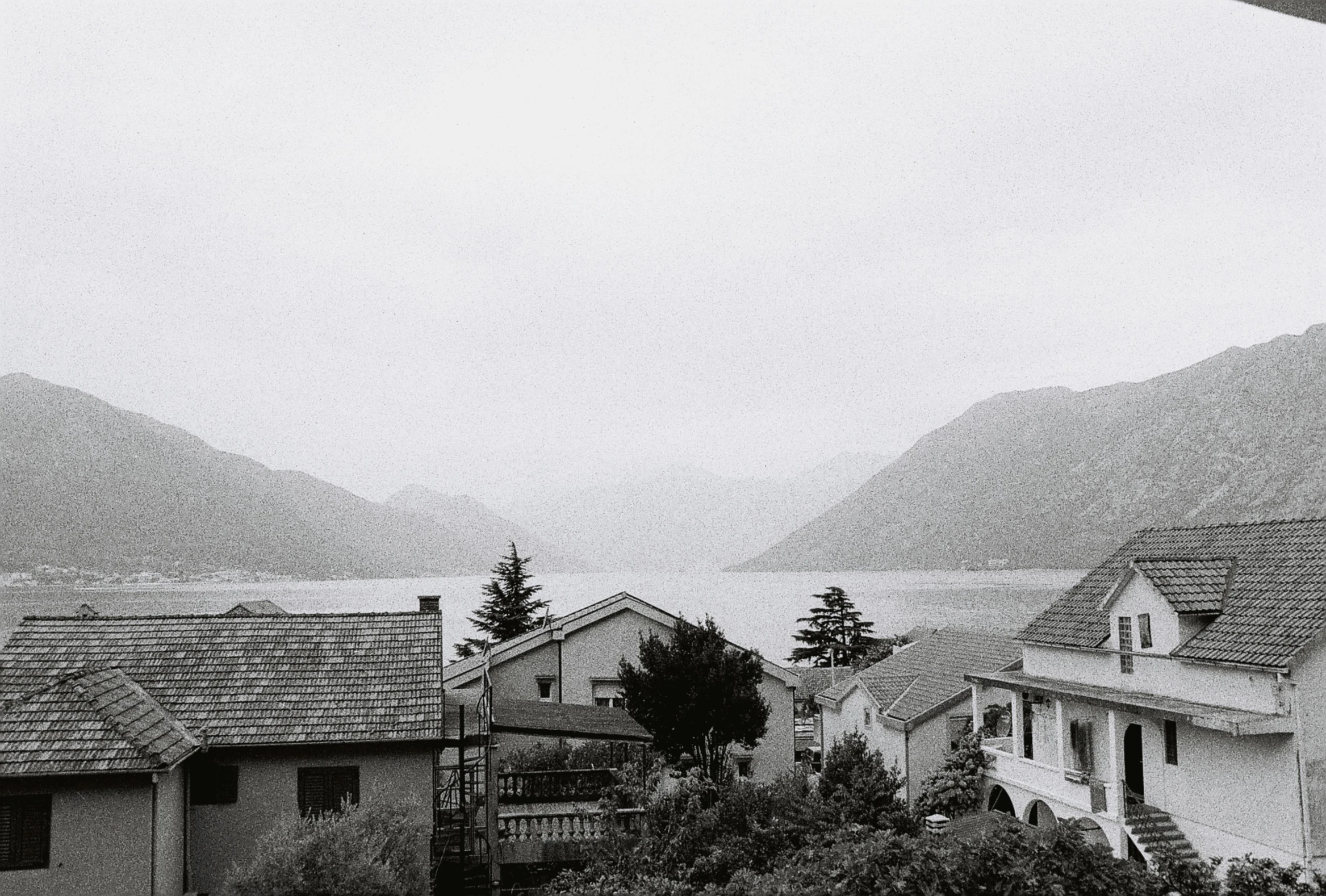 black and white po of mountains over a village