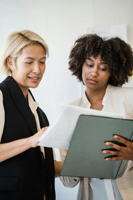 a woman standing by a man reading a document