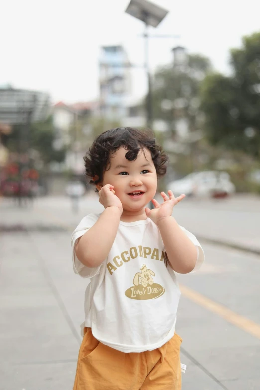 a baby in yellow pants and a white shirt