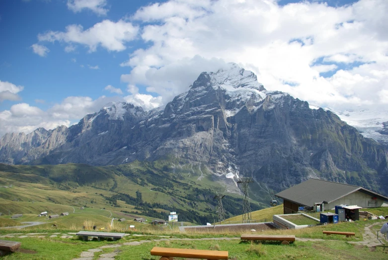 there are several benches and buildings at the base of the mountains