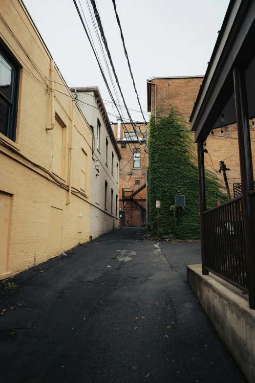 a road is lined with tall buildings in a alley