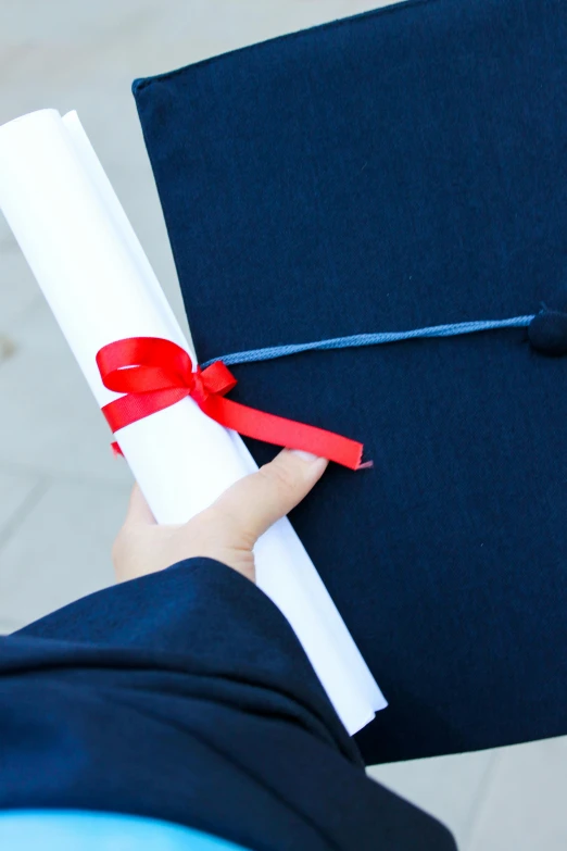 a graduation cap is tied up with red ribbon