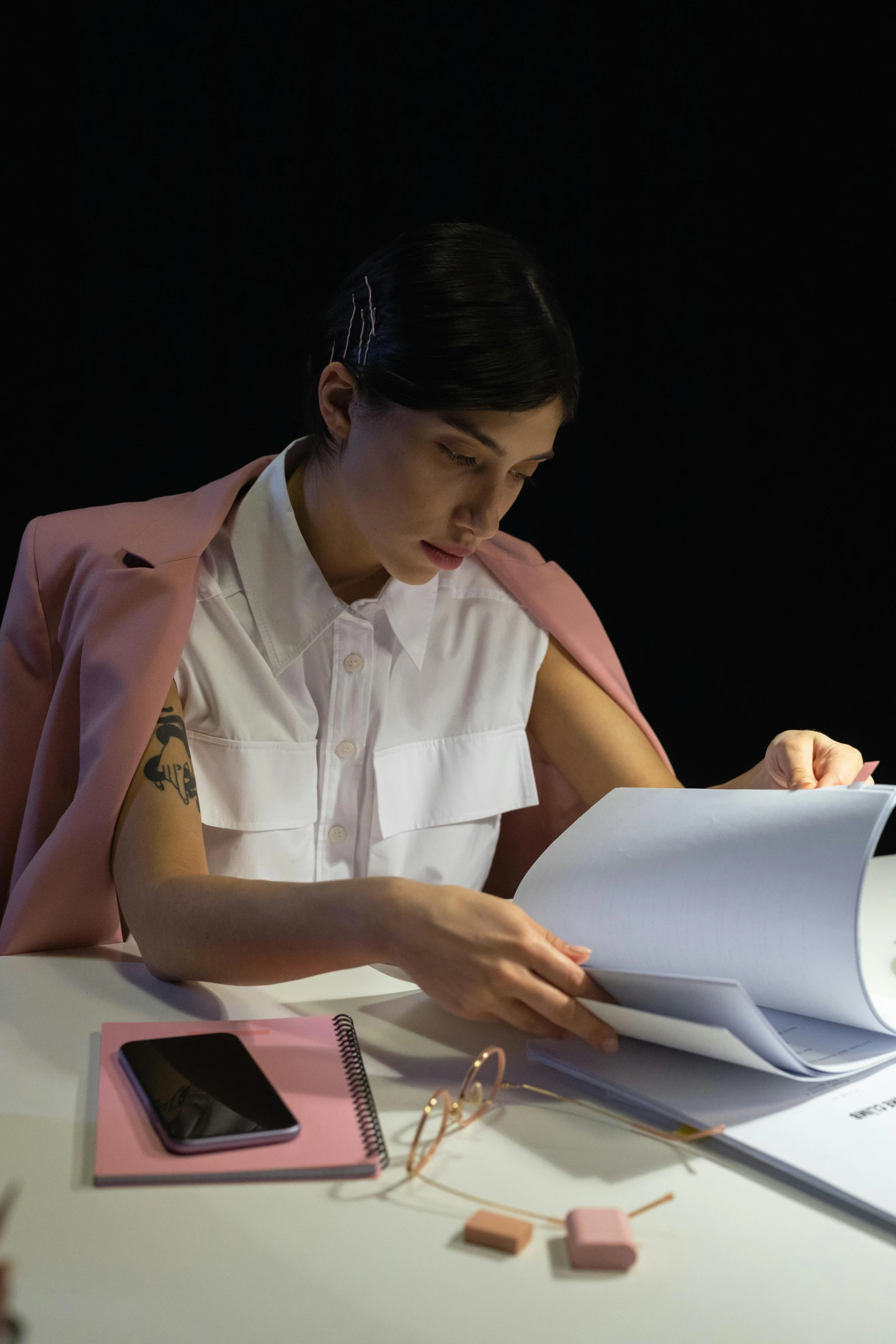 woman working on book at table with book on it