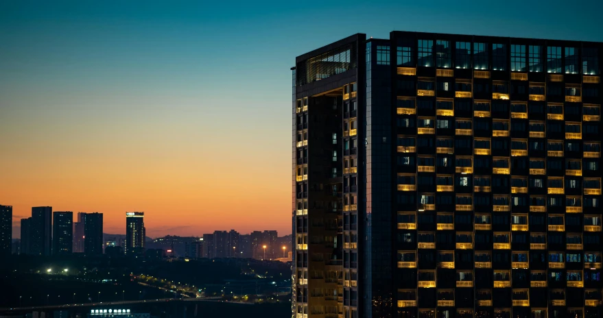 a cityscape at night, the sun is setting on a building in the distance