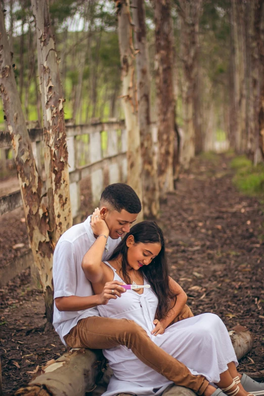 an attractive woman hugging her husband on a rock