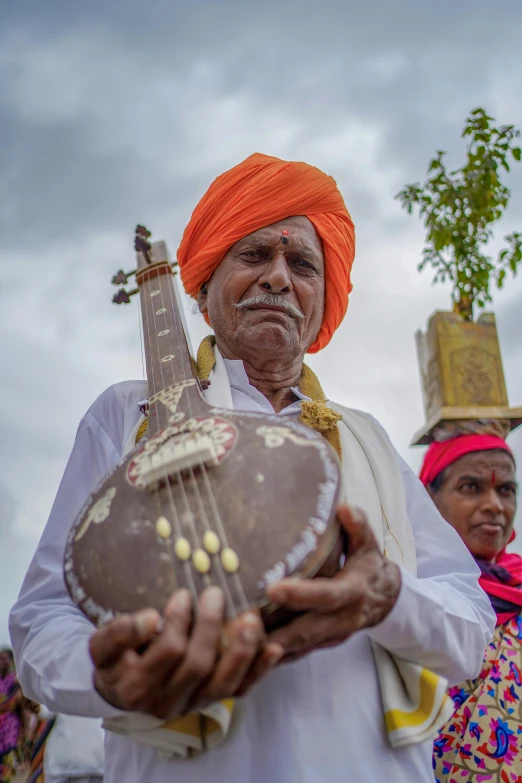 this man is dressed in orange holding a gourmet instrument