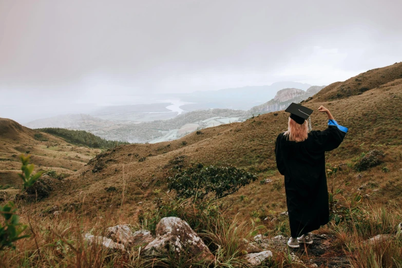 the woman is walking on the side of the hill