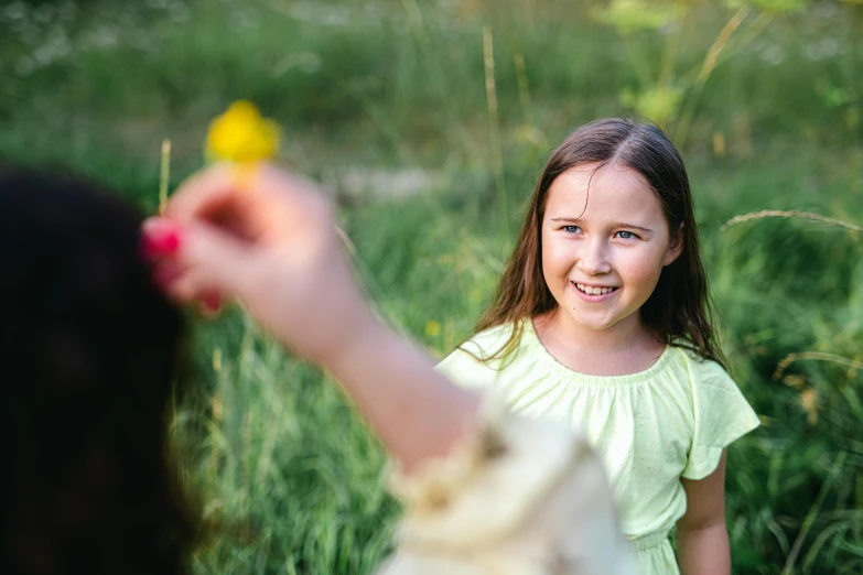 girl in a field holding an object up