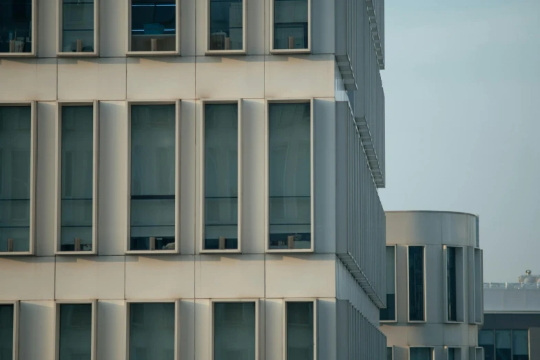 the front of an abstract white building with a large window