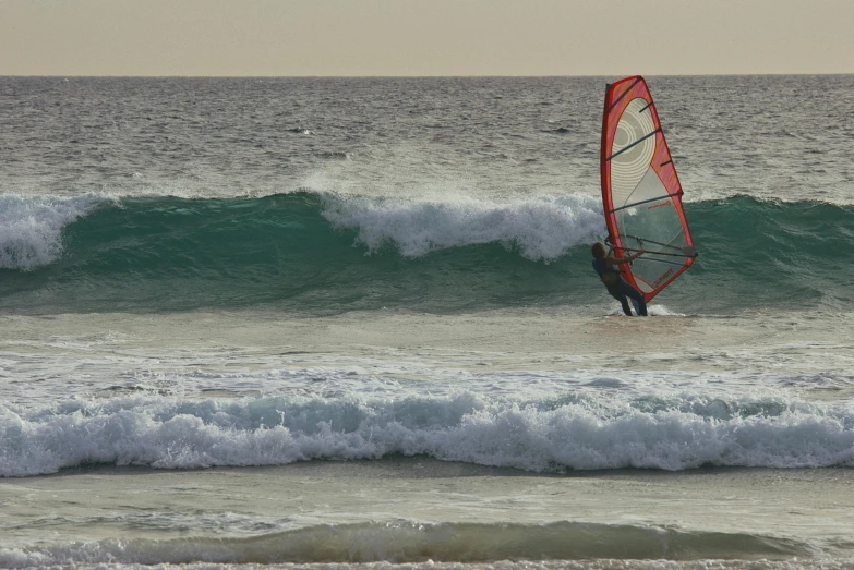 a man para sailing over a large wave in the ocean