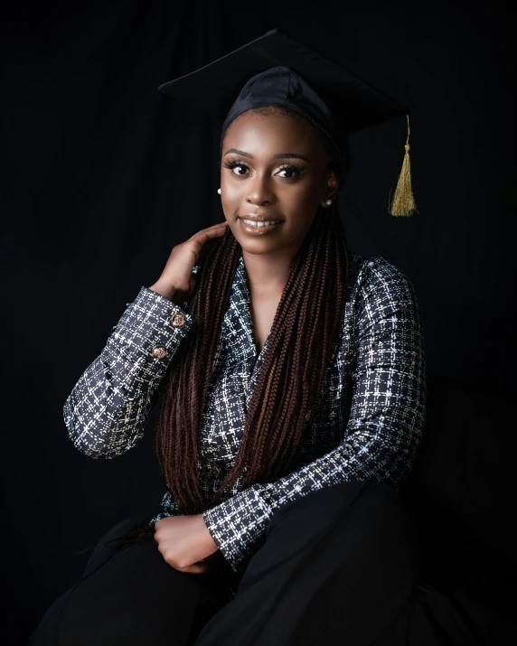 an african american female in black and white attire wearing a graduation cap