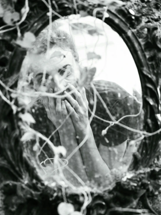 a woman standing next to a mirror brushing her teeth