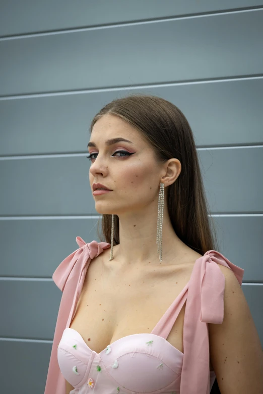 a woman in pink and earrings on wearing a pink shirt