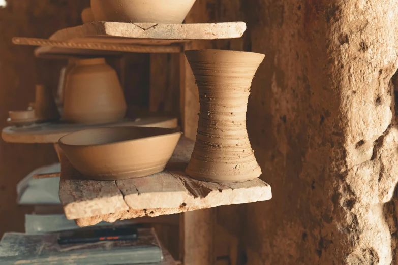 several clay containers and plates are sitting on a rack