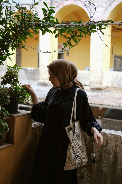 a woman standing on a balcony with plants