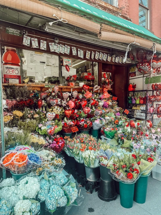 several buckets of flowers and flowers outside a flower shop