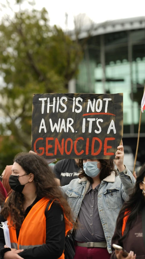 a woman holding up a sign saying no war, no side