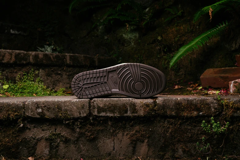 a worn pair of shoes on top of a concrete wall