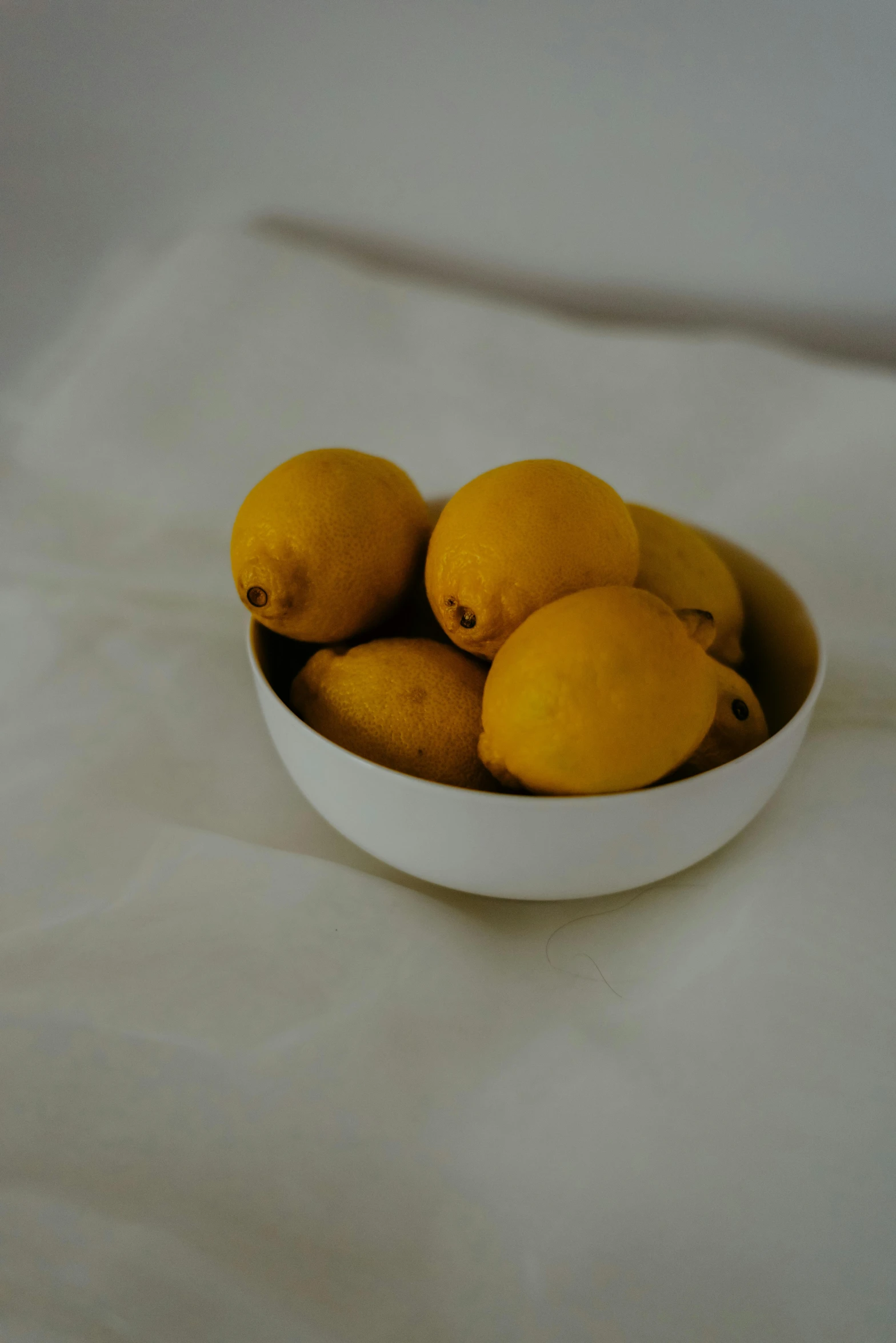 some fruit in a white bowl on top of a white table