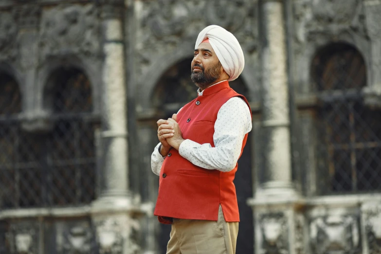 man with turban standing in front of a building