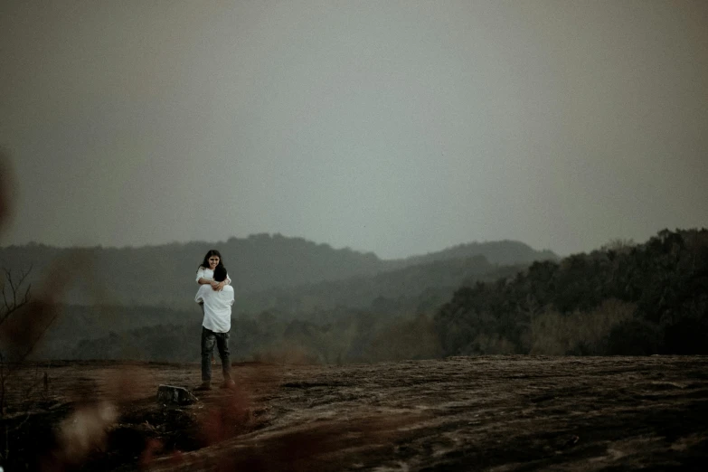 a woman standing on top of a rocky field