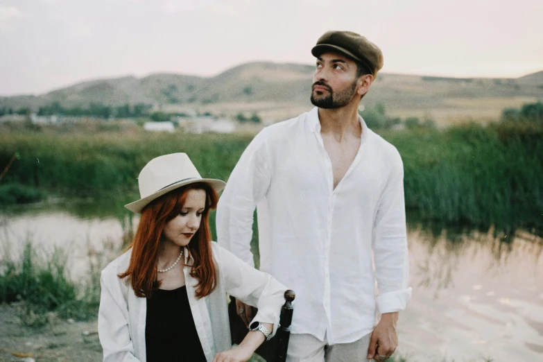 a woman wearing white and a man holding the hands of each other