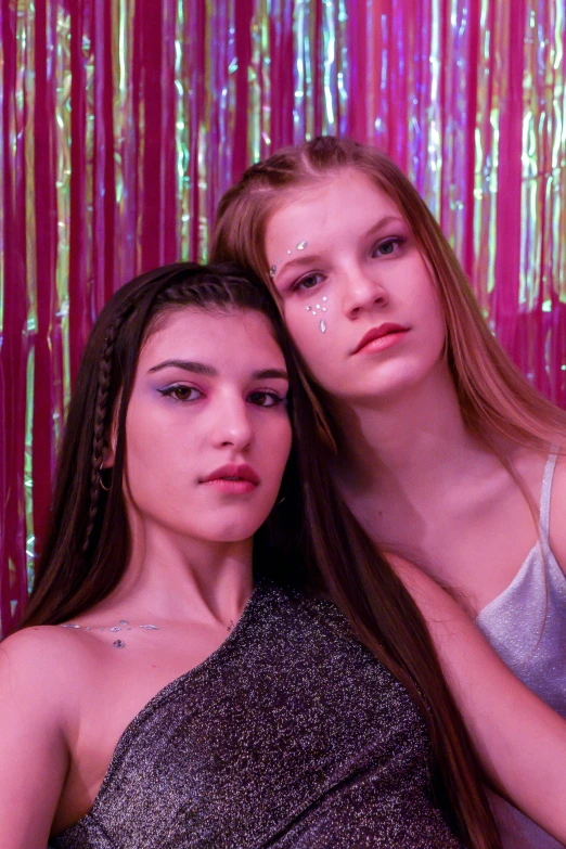 two girls dressed in sequines posing for the camera