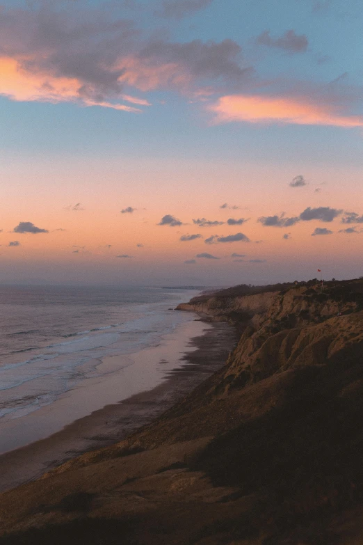 a person standing on the beach watching the sunset