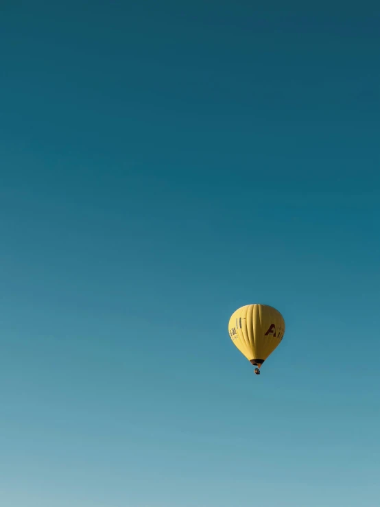 there is a yellow balloon that is flying in the sky